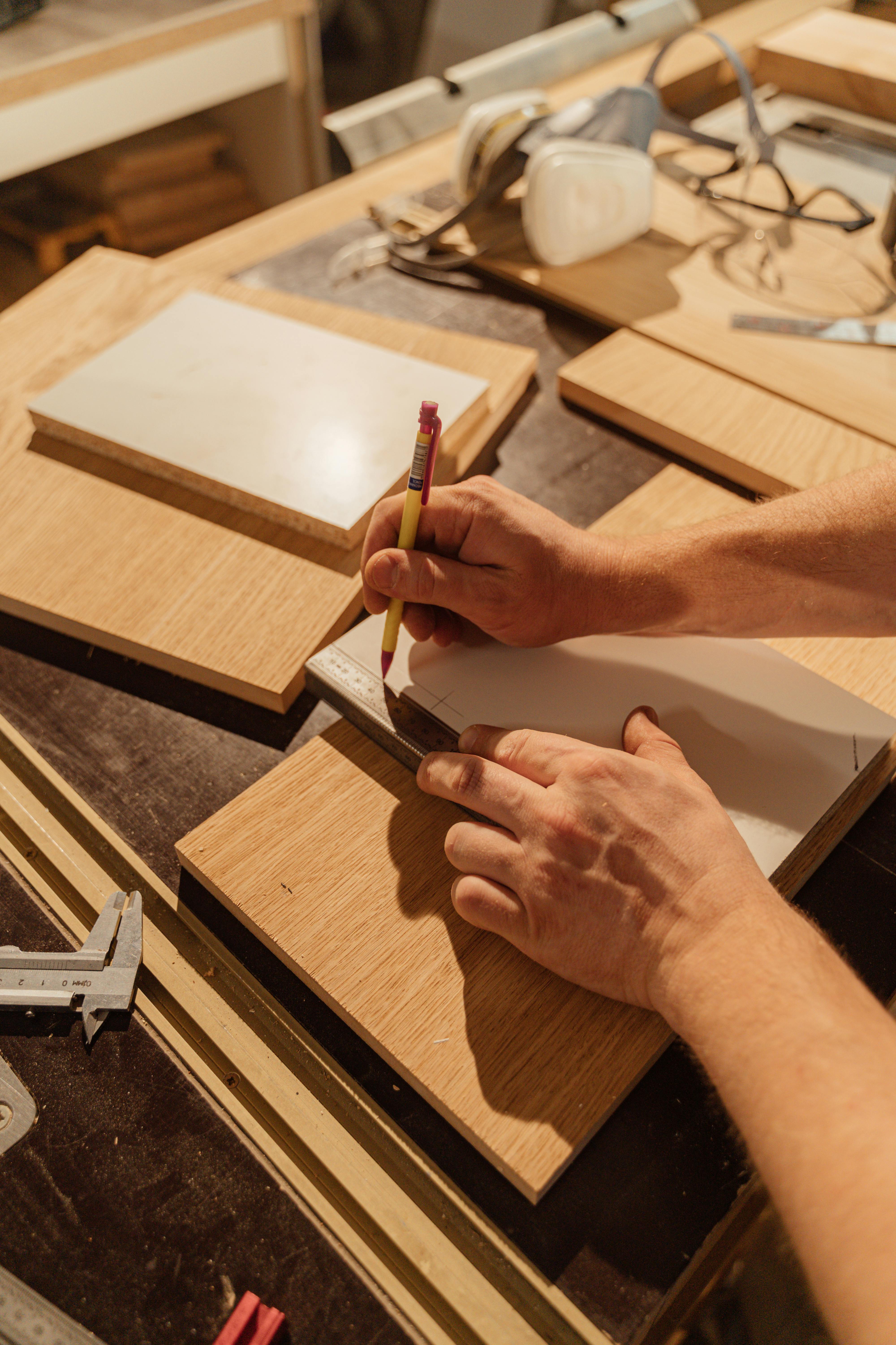A craftsman measuring hardwood in the workshop
